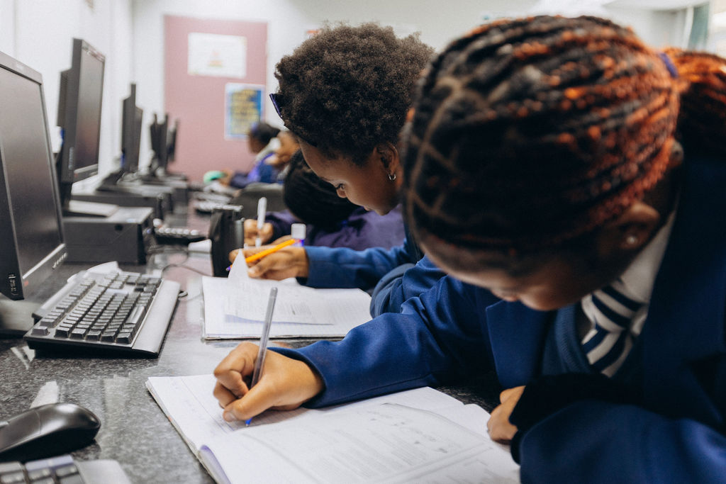 Learners studying beside computer workstations